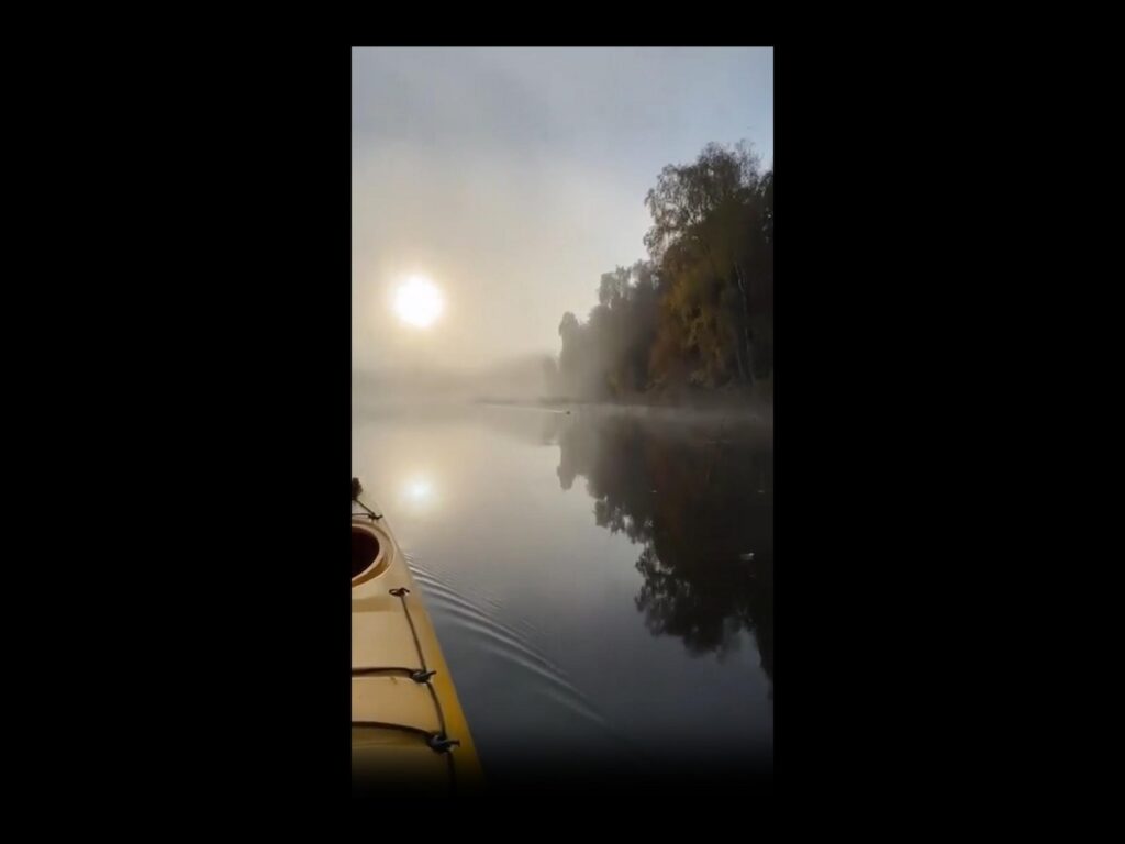 朝霧の立ち込める川を進むカヤック