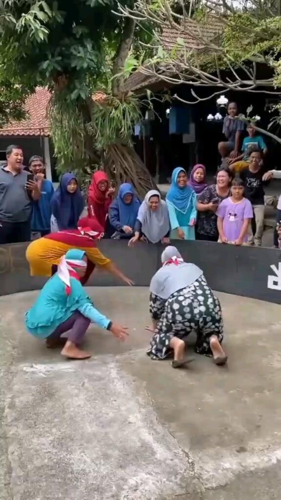 色とりどりの服の人間が目隠しをして這う