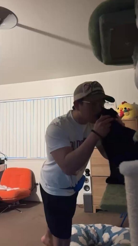 黒い猫に顔を寄せて可愛がる男性